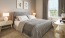 a bedroom with a bed and lamps
