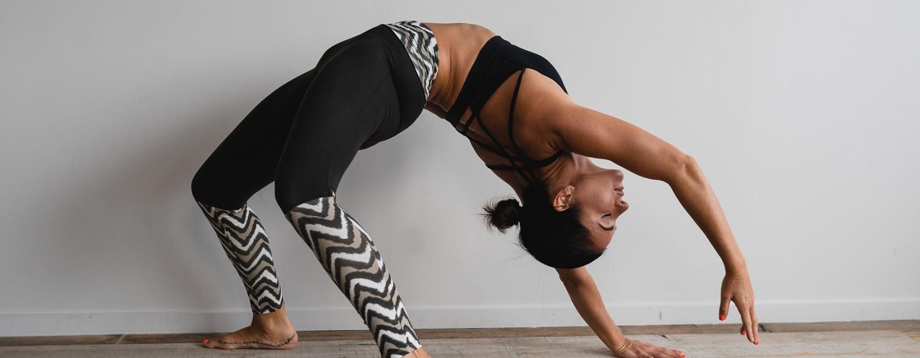 woman bending over backwards in an exercise studio